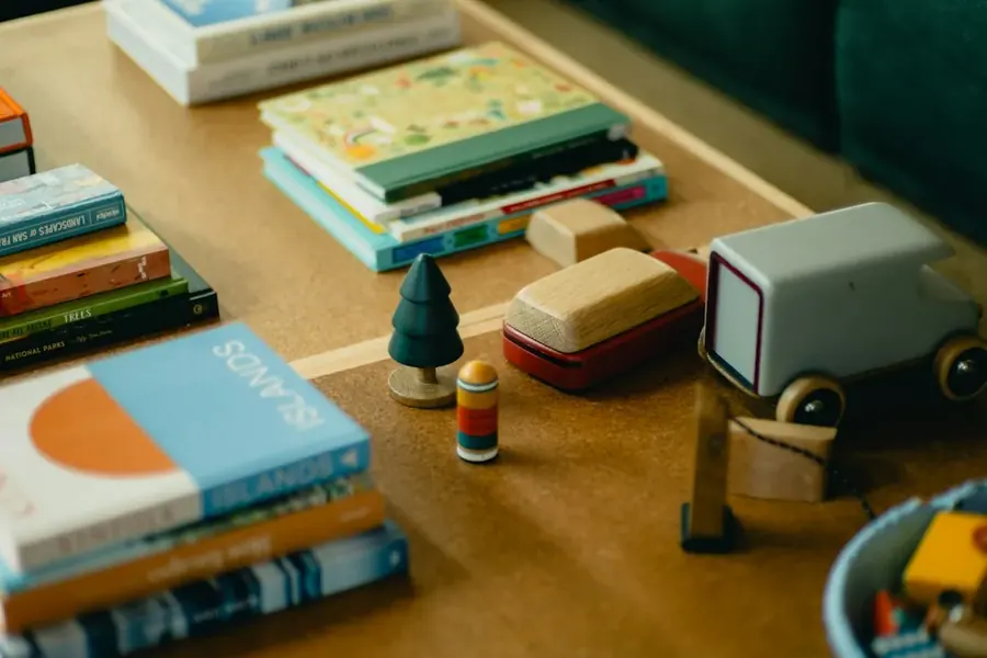 Picture books and small wooden toys arranged on a wooden table at home.